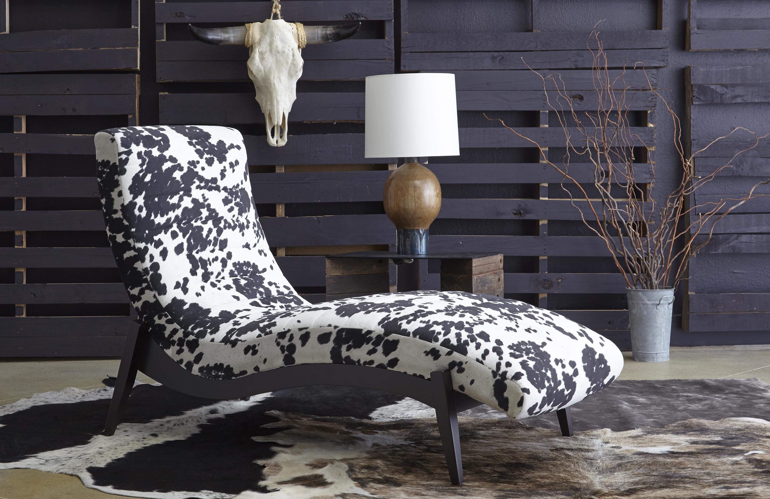 black and white cowhide spotted harlowe-lounger in western themed room